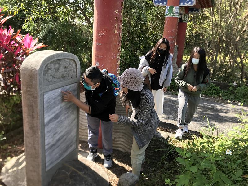 小組學生研究光華村牌樓旁石碑上的文史紀錄。