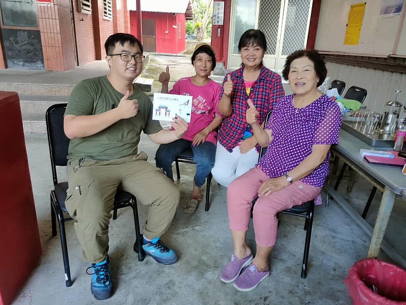 小組組長謝誌陽與在地居民分享繪本合影。