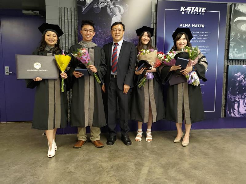 中興大學獸醫學系4位畢業生吳宣薇（右2）、林祐萱（右1）、賴勃宇（左2）、王禹心（左1），取得跨國獸醫學士雙聯學位，5月底出席堪蕯斯州立大學畢業典禮，興大獸醫系周濟眾教授（中）特地赴美參與畢典。