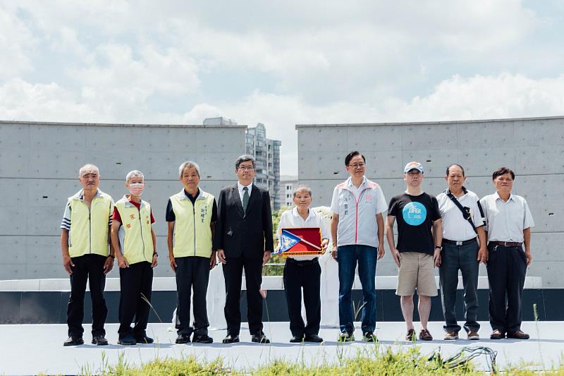 圖4 由楊長鎮主委與張善政市長致贈藍地黃虎旗予當年戰役中犧牲的先烈遺族