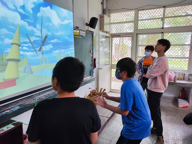 東華資工系學生認真指導學生如何遊玩。