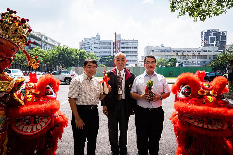 上週六(8日)於高科大建工校區化材館舉辦化材系創系一甲子慶祝活動，校友總會會長譚本榮（左）、化材系友會會長陳俊六（中）及化材系系主任李建良，分別從舞獅口中接下象徵好彩頭、好運的白蘿蔔及鳳梨。