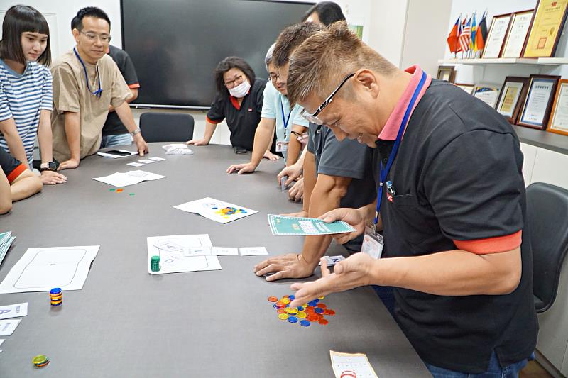 廠長楊國英（右）認為結合生產狀況跟遊戲，比在紙張上教育還要更生動、更快。