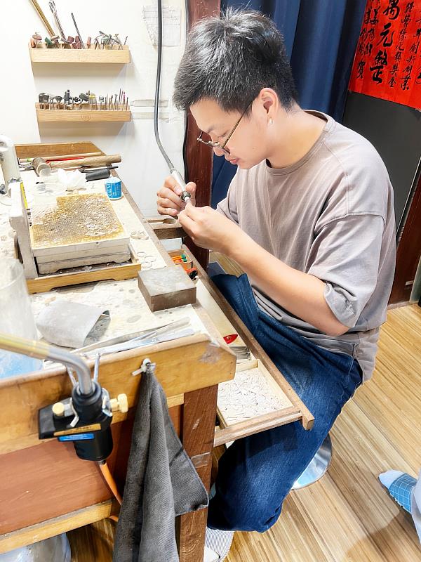 庭口金工店主胡朝綱,專心幫顧客製作的銀戒拋光