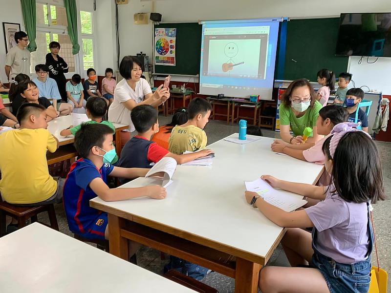 世新英語系師生帶領小學生瞭解英語文章、歌曲中的涵義。（世新大學提供）