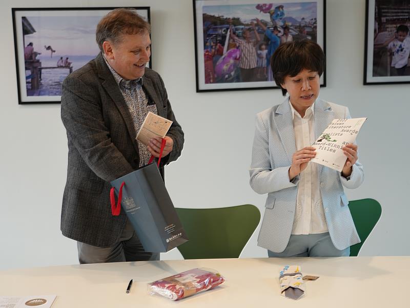 （右）臺文館館長林巾力向（左）萊頓大學圖書館副館長馬可．德．尼特（Marco_de_Niet）介紹2022臺灣文學獎入圍暨得獎作品書介與文創商品。（圖／萊頓大學提供）