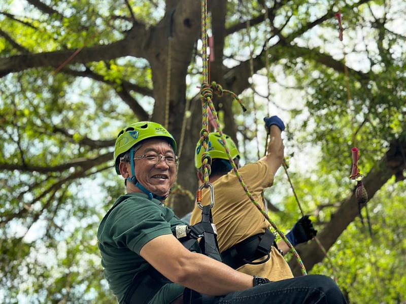 圖片說明：全聯前副董事長謝健南在生態保育青年蔡孟言的協助下，體驗攀樹活動，親身感受自然生態。