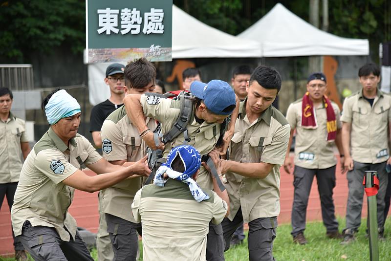 「負重跑走-競走大力士」護管員將20公斤背包上肩並進行調整