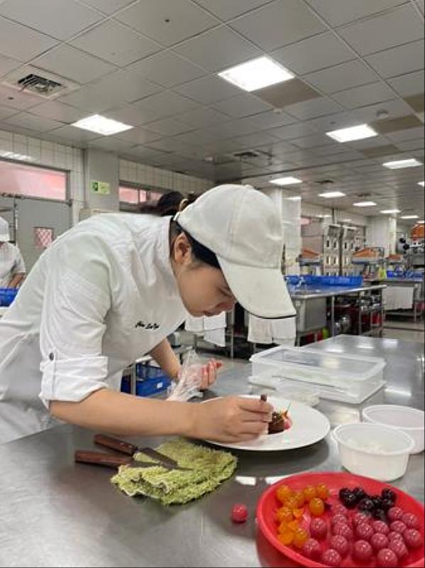 南臺科大餐旅系陳思妤同學在學校烘焙教室練習盤式點心之情形。
