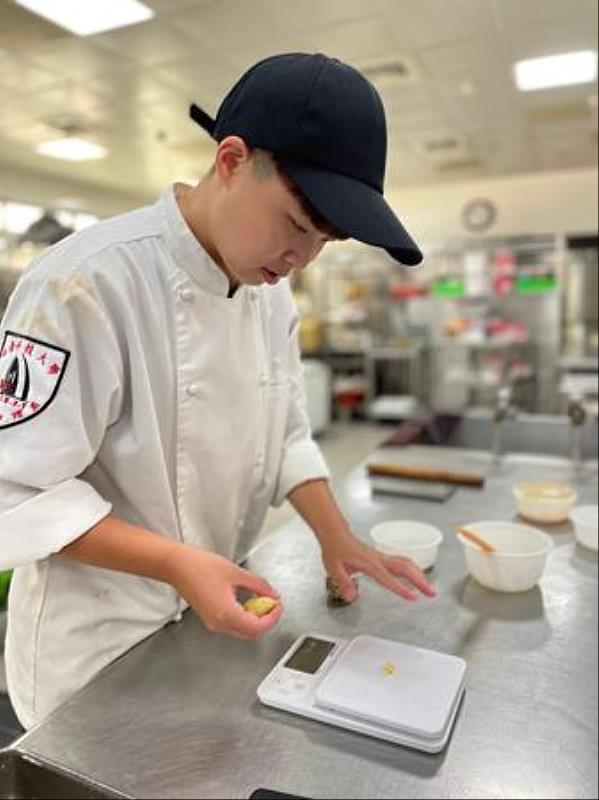 南臺科大餐旅系王榆芝同學在學校烘焙教室練習觀光伴手禮作品之情形。