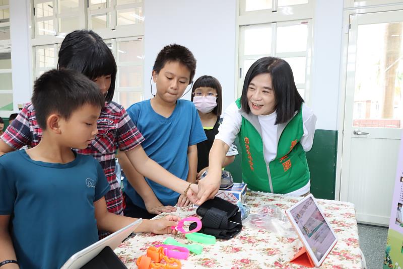 張榮發基金會執行長鍾德美（右一）與學生一起以顯微鏡觀察鬼針草。