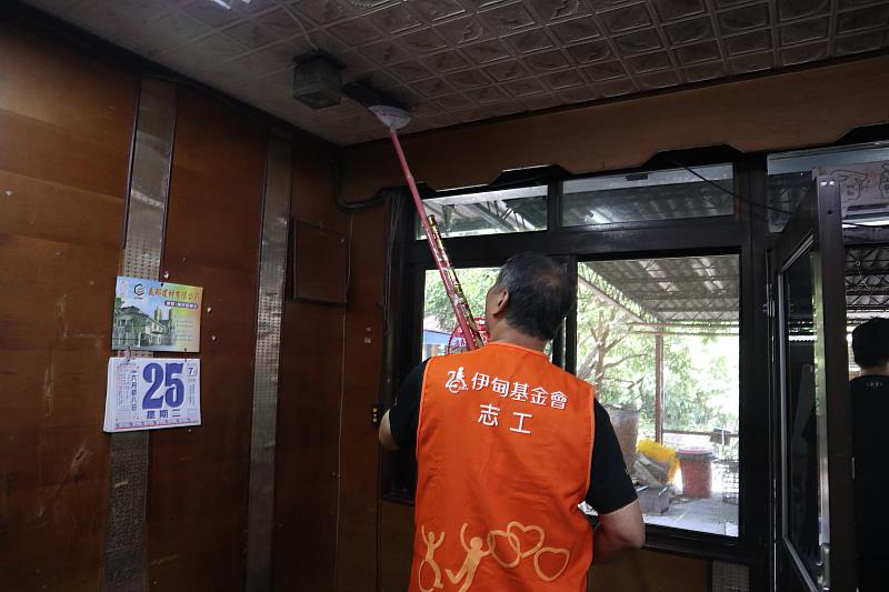 志工協助阿嬤清除天花板的灰塵，給予阿嬤煥然一新的家園