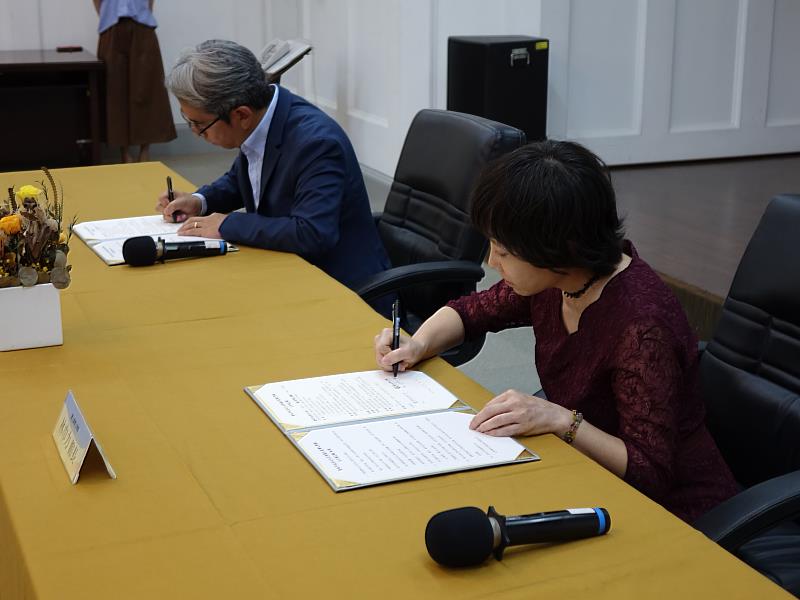 國立臺灣文學館長林巾力（右）與臺南市政府文化局長謝仕淵（左）在貴賓見證下，簽下合作備忘錄。
