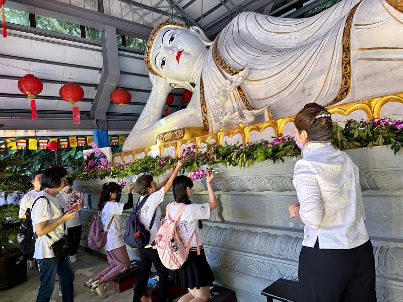 回到寂光寺，大家恭敬持蘭花供養白玉臥佛，並頂禮佛足，為佛陀獻上虔誠的敬意。（靈鷲山佛教教團提供）