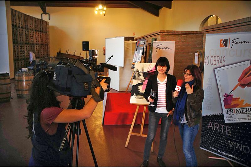 楊侖接受西班牙電視新聞媒體專訪，身後即為奪得首獎的藝術跨界紅酒畫作。