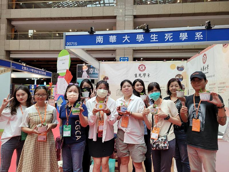 南華大學生死系參加台北國際照顧博覽會，民眾參加「園藝治療」體驗，展示手作成果並合影。