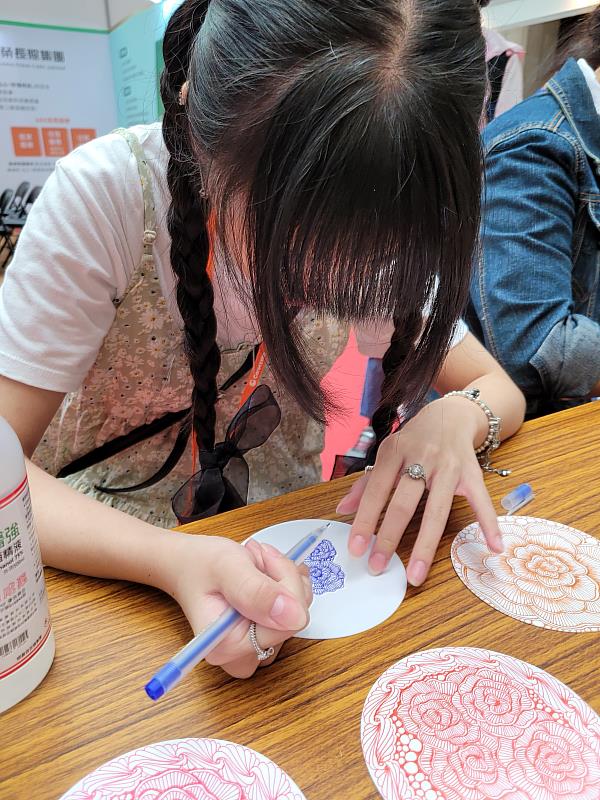 南華大學生死系參加台北國際照顧博覽會，提供身心療癒體驗，參與者進行禪繞畫。