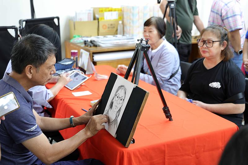 聽障畫家郭慧蘭與洪裕嘉於發表會現場為民眾繪製肖像畫