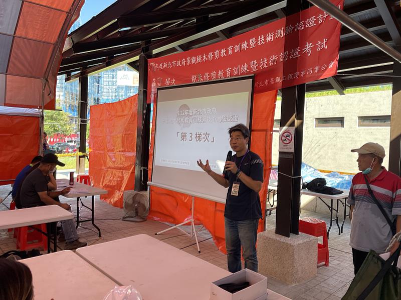 景觀處邀請臺灣省園藝技師公會副理事長曹明利老師帶領學員們到戶外實地演練,以實例講解如何正確安全地使用工具進行樹木修剪作業,圖為演練前之說明