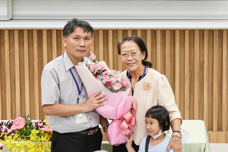 中文系主任巫俊勳獻花與楊麗圭女士偕同孫女合影。