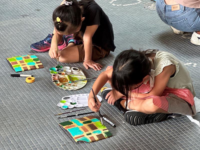 小朋友與藝術家林瑩宣共同創作在瓦片上色