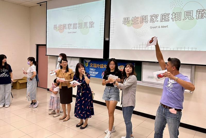 信物配對遊戲環節，拆開手中信封並唸出裡面圖卡上的台灣小吃，圖案相同者即為配對的學生/志工家庭。