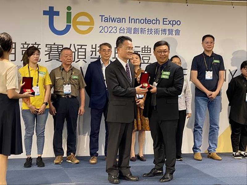 經濟部智慧財產局局長廖承威(左)頒發「金牌獎」獎牌，給創新產品設計系歐陽昆教授(右)，作品「肘下義肢手臂總成」。