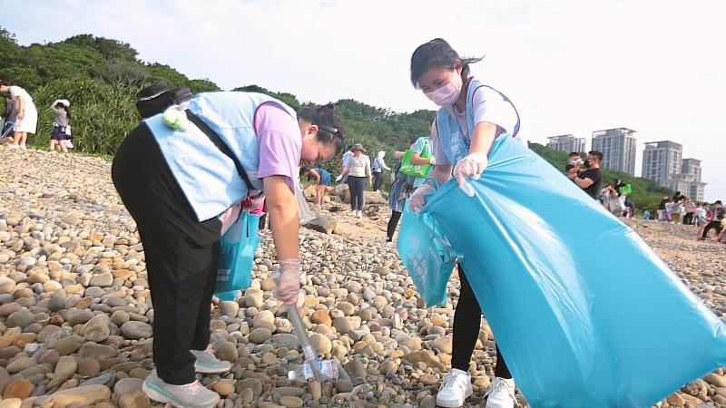 同學認真撿拾丟棄在沙灘上的廢棄寶特瓶。