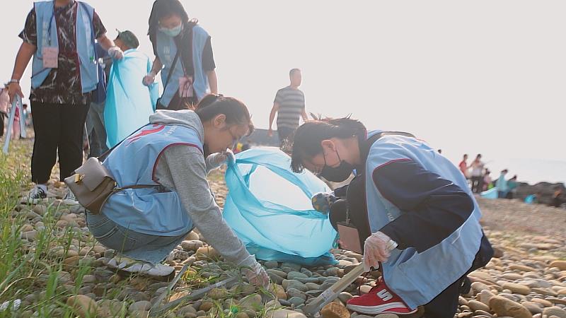 同學仔細將卡在沙地裡面的廢棄垃圾挖掘出來，恢復沙灘乾淨環境。