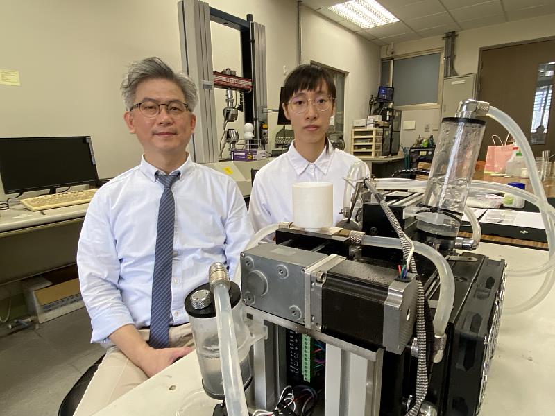 成大材料系特聘教授洪飛義（左）與博士生黃嫈庭研發血管支架全球創新材料 PLAM，未來有機會嘉惠心血管疾病患者，前方為製作支架的精密微型射出機