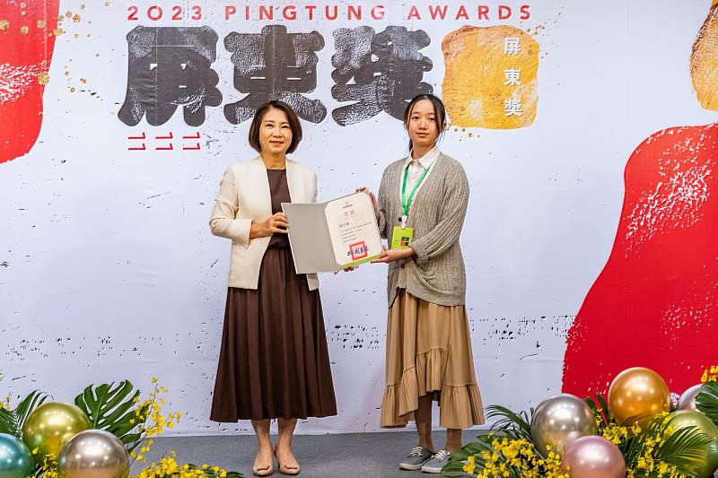 創作者張宇青同學（右）於屏東美術館接受屏東縣長周春米（左）親頒優選獎狀。