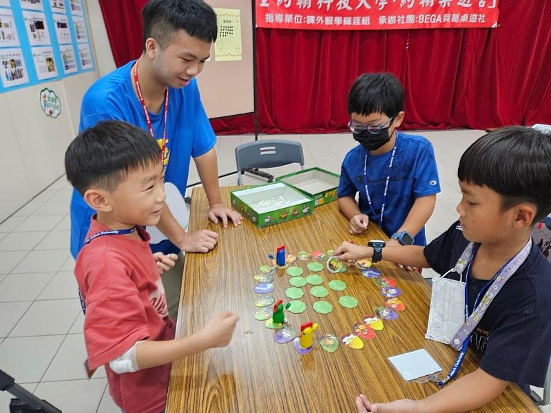 吳少綸同學帶領學員體驗不插電的桌遊遊戲，小學生專注認真的玩遊戲。