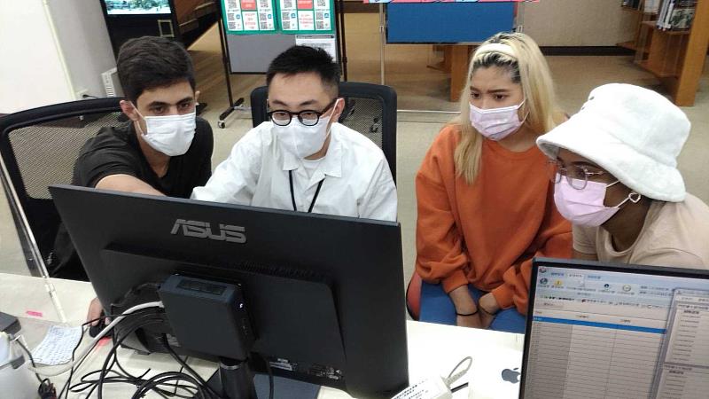 周志文（左2）為外籍學生進行諮詢服務