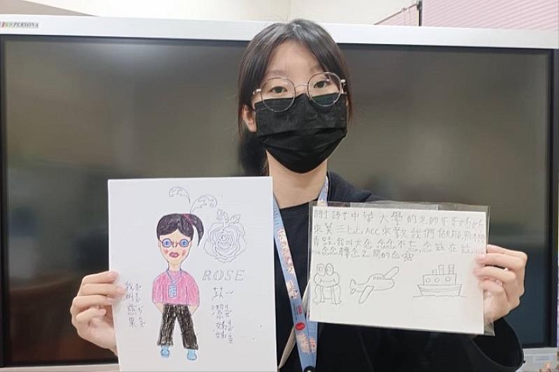 圖／國際志工團長林苡潔拿著孩子送給他的畫作和手寫信，相當感動！孩子們的畫作與志工服務照片皆可在中華大學行政大樓一樓欣賞。