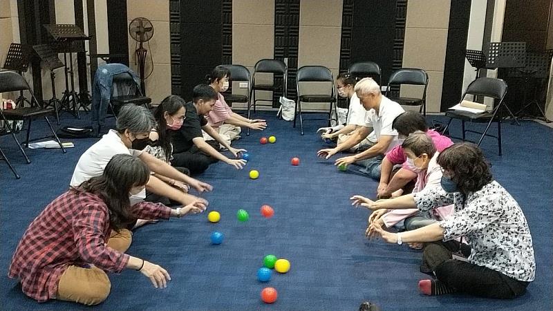 樂活學程學生在培訓課程中利用球類帶領長輩進行音樂輔療活動