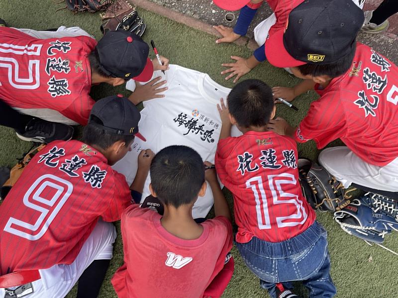 新城國小棒球隊孩子在衣服上簽名送給捐款人(頂新和德文教基金會提供)m.jpg