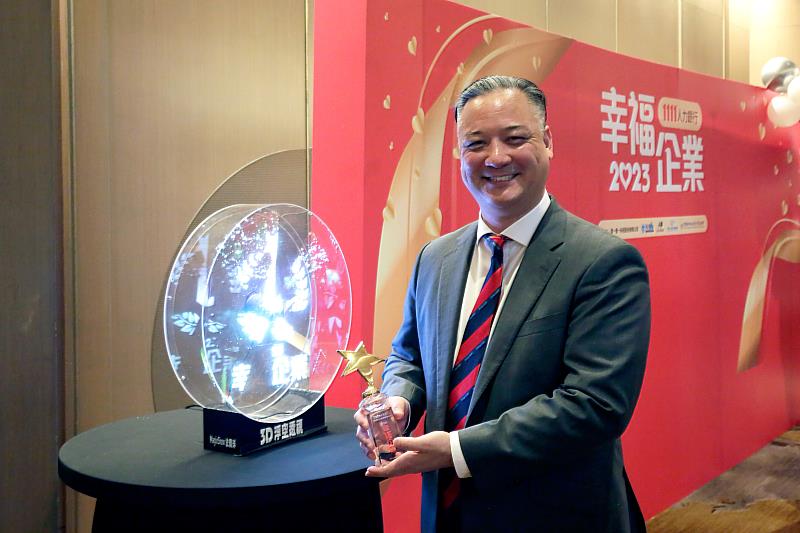 TutorABC聯合董事長楊順銓手捧「2023幸福企業」金獎獎盃。