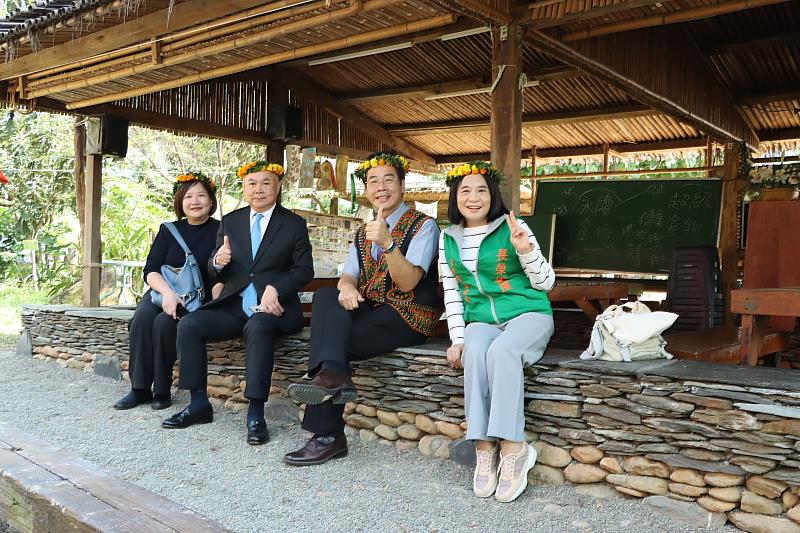 長榮百合國小校長陳世聰(右二)向基金會執行長鍾德美(右一)、長榮海運董事長張衍義(左二)介紹傳統石板屋。(張榮發基金會提供)