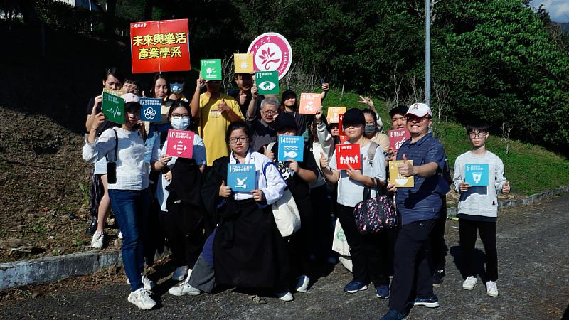 圖說：佛光大學教師與同學共同手持17項永續發展目標，師生共同種樹達到碳中和，邁向2050淨零減碳的目標。