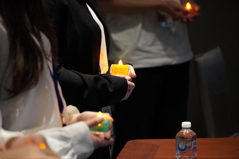 圖／同學們手拿蠟燭向在座師長們舉行拜師禮，場面溫馨。