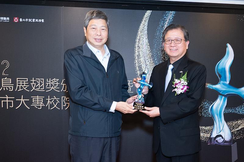 國立臺北商業大學任立中校長(右)接受勞動局局長高寶華頒獎。