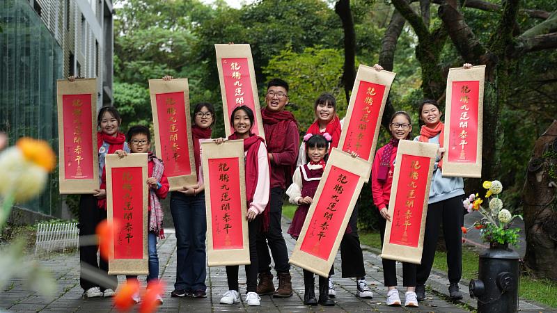 基隆普仁志工及小太陽手拿2024年春聯墨寶，祝福龍年平安。（圖由靈鷲山佛教教團提供）