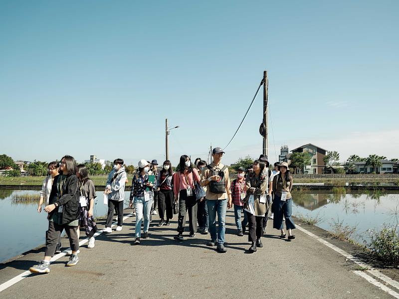 穀東俱樂部賴青松老師與青小旅行旅客漫步田野間分享人與土地的關係