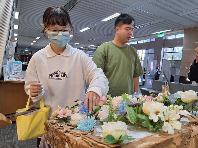 學生挑選乾燥花產品為花書進行裝飾