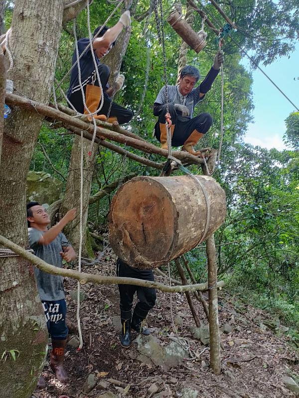 麻必浩部落族人協力輪流接手拉滑輪將木頭運送下山