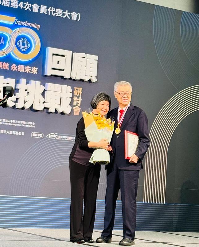 東吳大學法商講座教授陳冲獲頒中華民國管理科學學會最高榮譽「管理獎章」，夫人上台獻花。