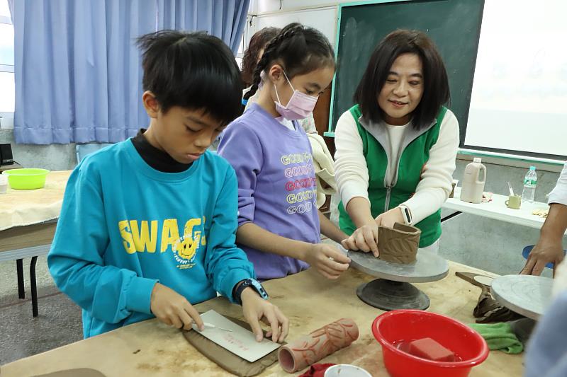 張榮發基金會執行長鍾德美（右）與藝文課程受惠學校代表豐榮國小陶藝班學生一起做陶藝。(張榮發基金會提供)