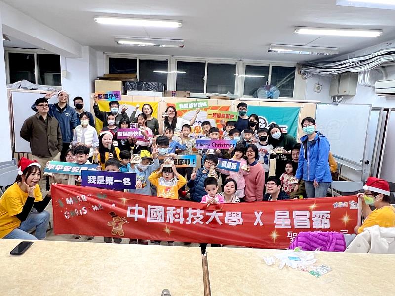 中國科大學生會大手攜小手帶領社區鄰里小朋友進行薑餅屋DIY，參與活動的家長與小朋友全體合影。（圖／中國科大提供）