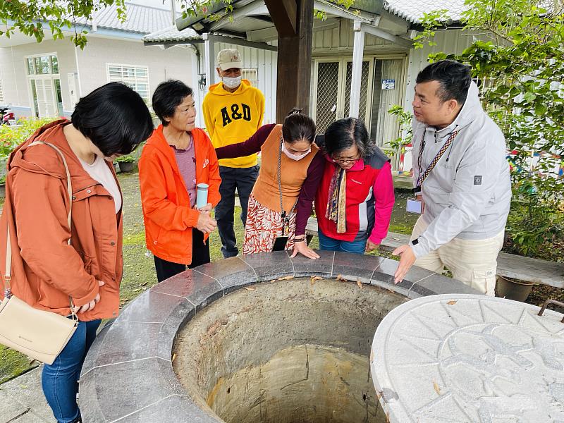 多元就業開發方案專案進用人員(右)向遊客介紹沙荖古井的由來