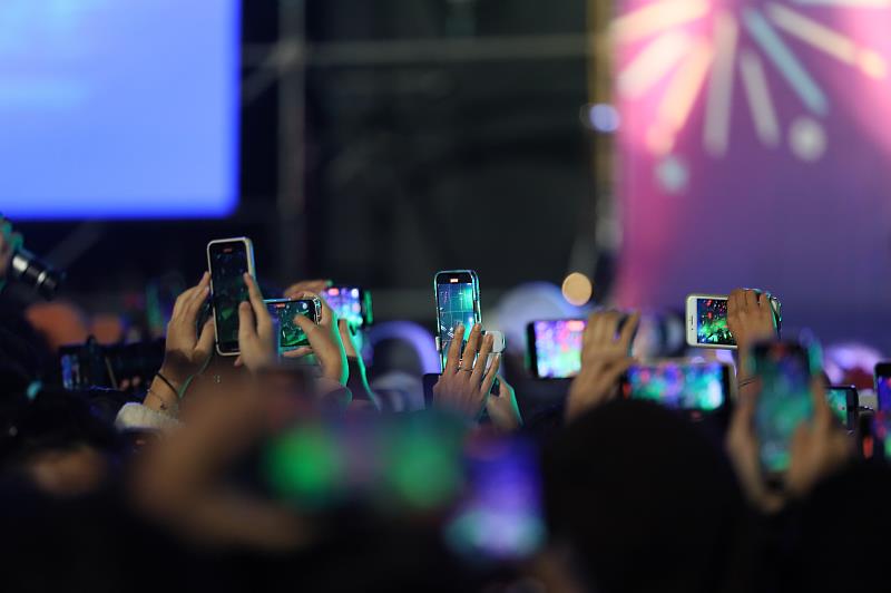 現場民眾舉起手機拍攝台上偶像